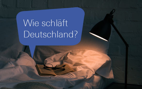 Sprechblase mit dem Text "Wie schläft Deutschland?" auf Bett im Schein einer Nachttischlampe