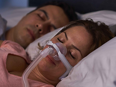 Schlafapnoe-Patientin trägt ResMed Nasenmaske