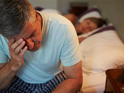 Mann leidet unter Kopfschmerzen und Morgenmüdigkeit aufgrund von Schlafapnoe